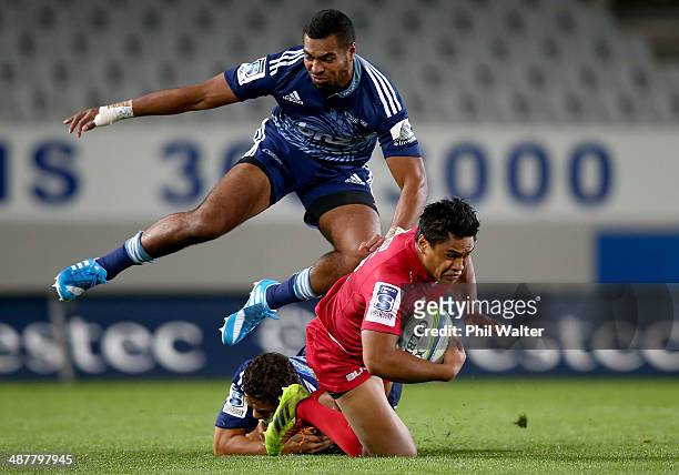 Ben Tapuai of the Reds is tackled by Lolagi Visinia of the Reds during the round 12 Super Rugby match between the Blues and the Reds at Eden Park on...