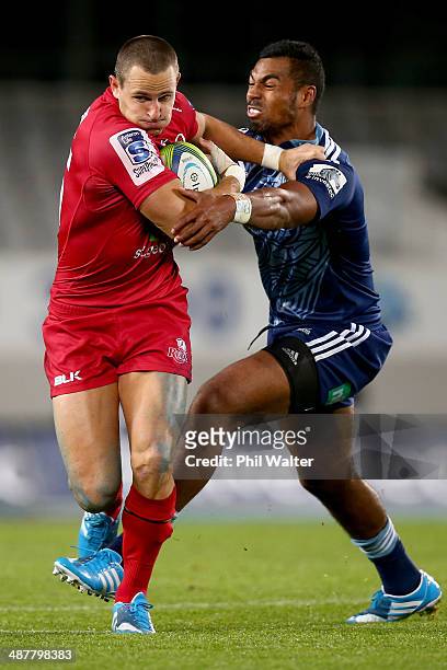 Mike Harris of the Reds is tackled by Lolagi Visinia of the Blues during the round 12 Super Rugby match between the Blues and the Reds at Eden Park...