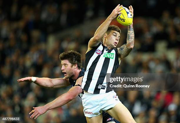 Jamie Elliott of the Magpies marks over the top of Sam Rowe of the Blues during the round seven AFL match between the Carlton Blues and the...