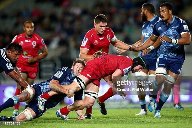 Liam Gill of the Reds is tackled by Tom Donnelly of the Blues during the round 12 Super Rugby match between the Blues and the Reds at Eden Park on...