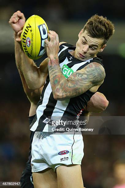 Jamie Elliott of the Magpies marks infront of Sam Docherty of the Blues during the round seven AFL match between the Carlton Blues and the...