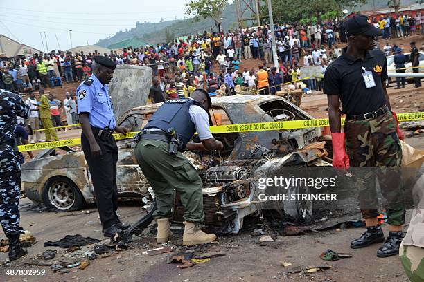 Nigerian security personnel inspect the site of a blast at Nyanya bus station in the outskirts of in Abuja on May 2, 2014. At least 19 people were...