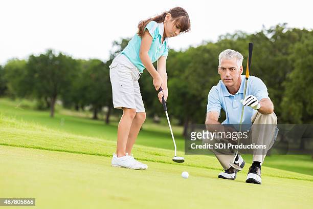 kleines mädchen nehmen sie golfunterricht vom country club-profi - golf girls stock-fotos und bilder