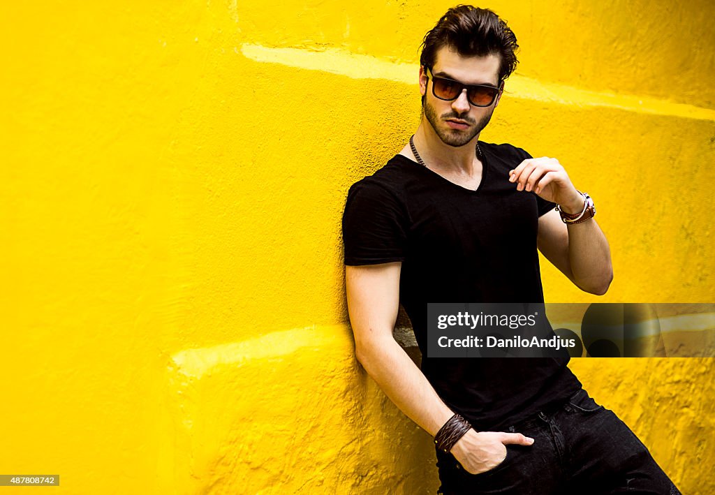 Fashionable handsome man isolated on yellow wall
