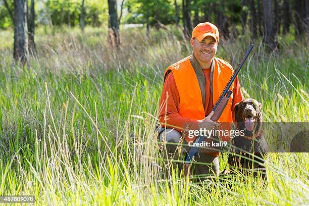 man hunting with shotgun kneeling next to retriever - jakthund tränad hund bildbanksfoton och bilder