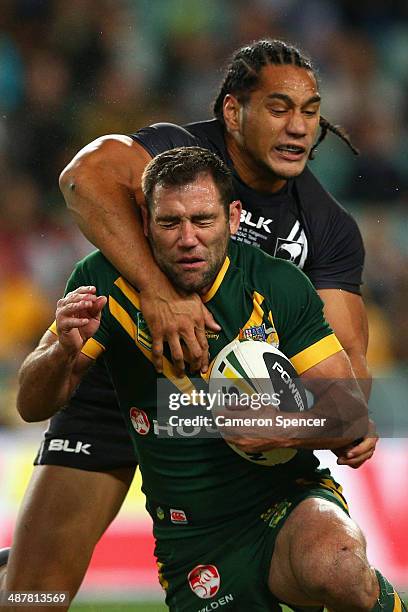 Cameron Smith of the Kangaroos is tackled by Martin Taupau of the Kiwis during the ANZAC Test match between the Australian Kangaroos and the New...