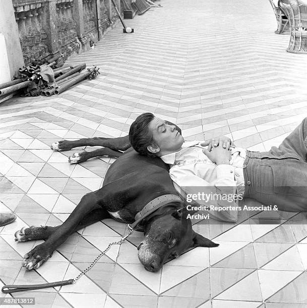 French actor Alain Delon pausing on the set of The Leopard, directed by Italian director Luchino Visconti. Lying on the floor, resting his head on a...