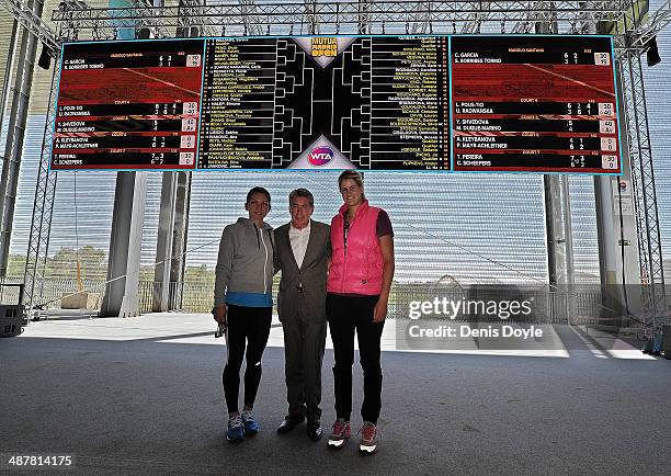 Tennis players Simona Halep and Maria Teresa Torro stand with former Spanish player Manolo Santana in front of the draw screen for the WTA Matua...