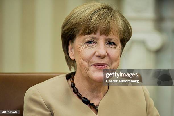 Angela Merkel, Germany's chancellor, smiles during a bilateral meeting with U.S. President Barack Obama, not pictured, in the Oval Office of the...