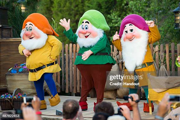 In this handout photo provided by Disney, Disney characters Doc, Happy Dwarf and Sleepy Dwarf take the stage to help dedicate the park's newest...
