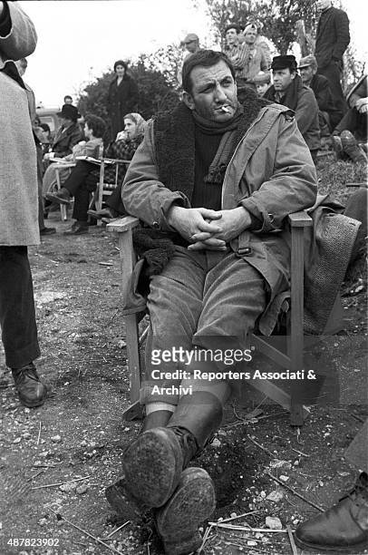 Italian actor Lino Ventura smoking during a break on the set of the film The King of Poggioreale. 1961
