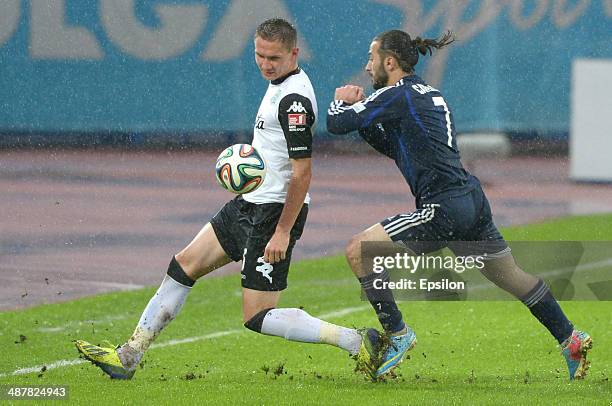 Artur Sarkisov of FC Volga Nizhny Novgorod challenged by Artur Jedrzejczyk of FC Krasnodar during the Russian Premier League match between FC Volga...