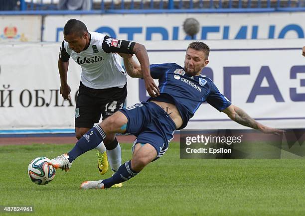 Aleksandr Shulenin of FC Volga Nizhny Novgorod challenged by Wanderson of FC Krasnodar during the Russian Premier League match between FC Volga...