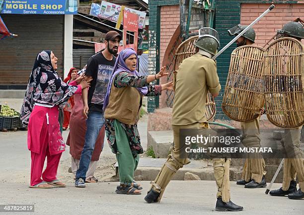 Kashmiri Muslims comfront Indian policemen after they arrested a youth during a protest at Hyderpora locality in Srinagar on May 2, 2014. Parts of...