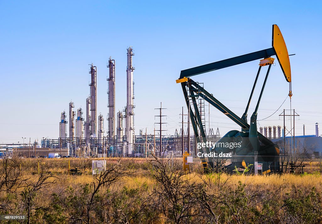 Pumpjack (aceite derrick) y la planta de refinería en el oeste de Texas
