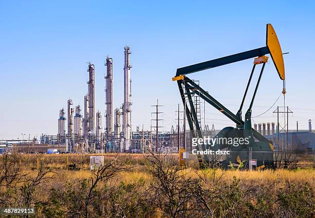 pumpjack (oil derrick) and refinery plant in west texas - crude oil stock pictures, royalty-free photos & images