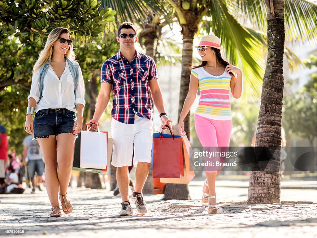 Friends walking on the street while coming back from shopping.