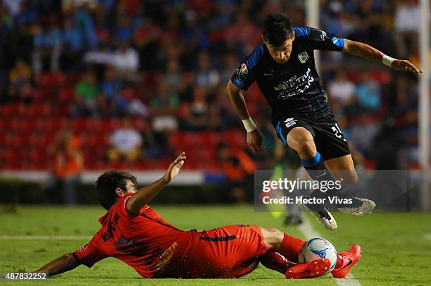 Edgar Benitez of Queretaro jumps over Facundo Erpen of Morelia during a 8th round match between Queretaro and Morelia as part of the Apertura 2015...