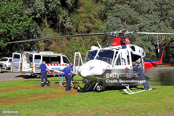 air ambulance helicopter evacuates rural accident victim to hospital - helicopter ambulance stock pictures, royalty-free photos & images