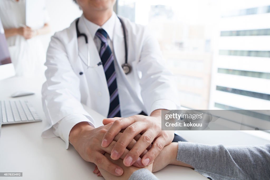 Doctor holding patient hand to give a support