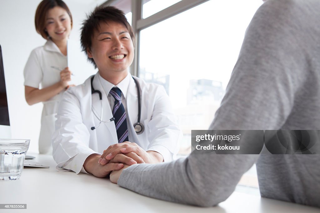 Handsome doctor talking with patient