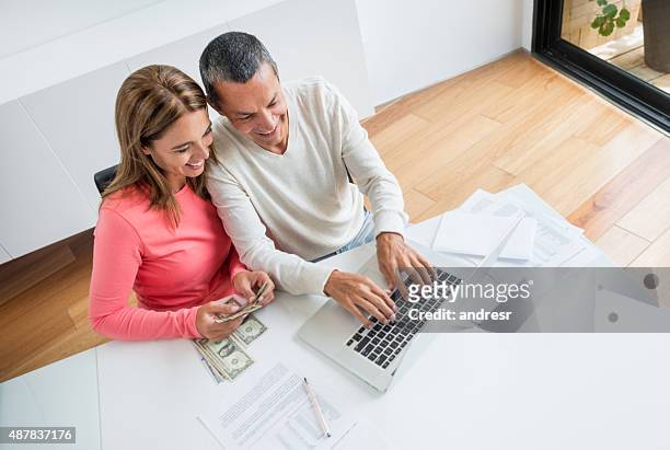 couple organizing their home finances - couple counting money stock pictures, royalty-free photos & images