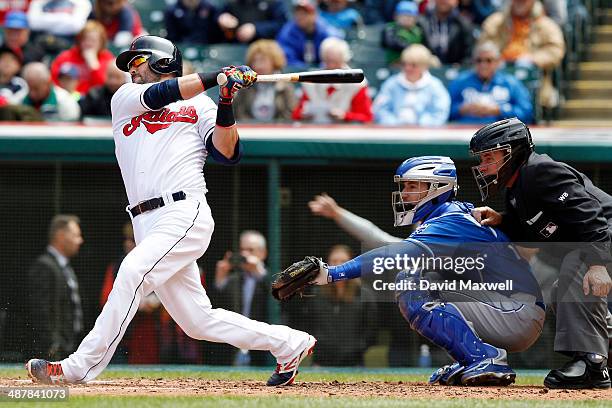 Nick Swisher of the Cleveland Indians fouls off a pitch as Brett Hayes of the Kansas City Royals looks on during the fourth inning of their game on...