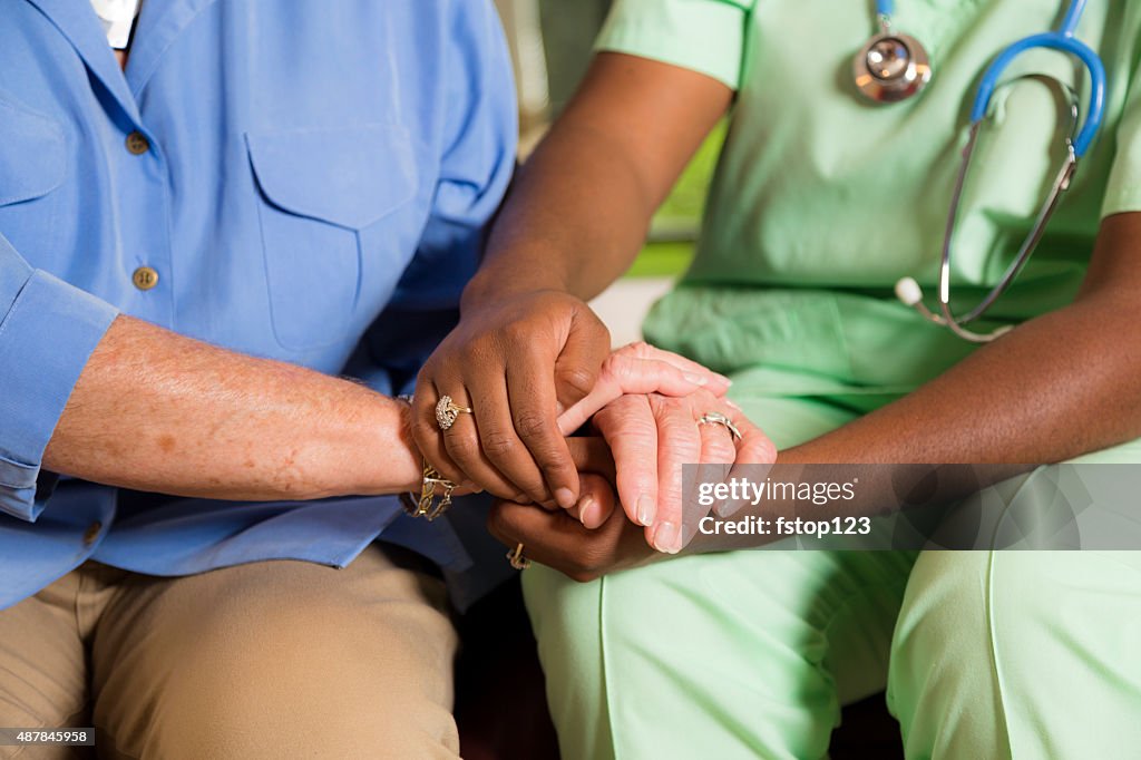 Casa healthcare enfermeira dá Idosa a s mãos.  Consoling. gentileza.