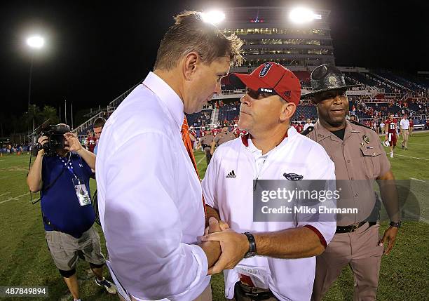 Head coach Charlie Partridge of the Florida Atlantic Owls shakes hands with Al Golden head coach of the Miami Hurricanes during a game at FAU Stadium...