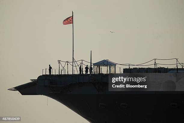 Navy sailors stand on the deck of the USS Enterprise aircraft carrier as it floats pier side during inactivation at Huntington Ingalls Industries'...