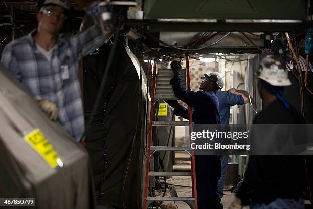 Employees work aboard the USS Gerald R. Ford aircraft carrier during outfitting and testing at Huntington Ingalls Industries' Newport News...