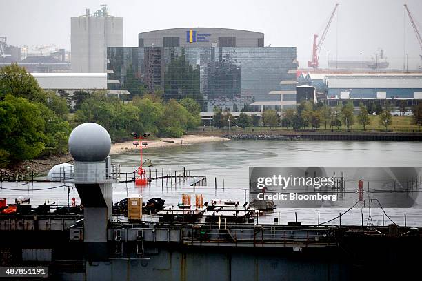 The Huntington Ingalls Industries Inc. Headquarters stands past the USS Enterprise aircraft carrier during inactivation at Huntington Ingalls...