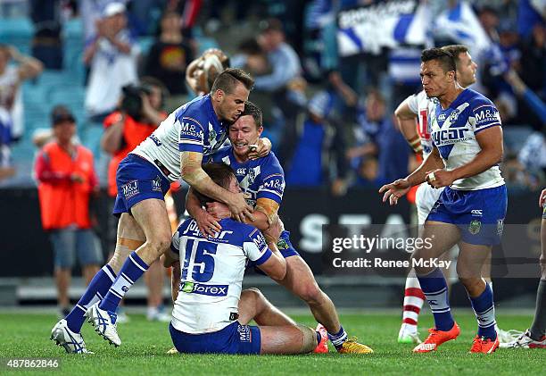 Shaun Lane of the Bulldogs celebrates his try with team mates Damien Cook and Josh Reynolds during the NRL Elimination Final match between the...