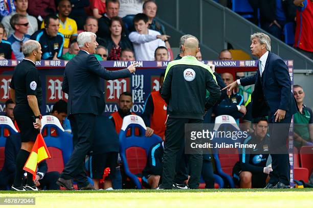 Alan Pardew, manager of Crystal Palace exchanges words with Manuel Pellegrini, manager of Manchester City during the Barclays Premier League match...