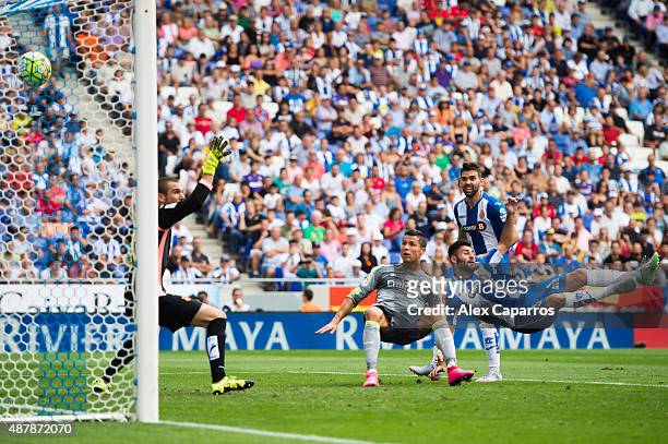 Cristiano Ronaldo of Real Madrid CF shoots towards goal with the opposition of Ruben Duarte of RCD Espanyol and scores his team's third goal during...