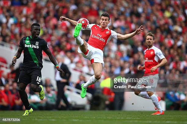 Laurent Koscielny of Arsenal controls the ball with Mame Biram Diouf of Stoke City during the Barclays Premier League match between Arsenal and Stoke...