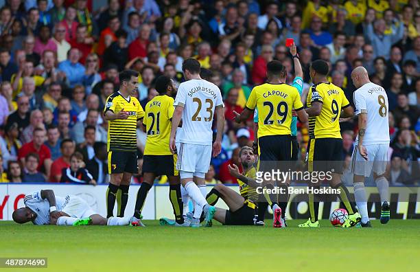 Valon Behrami of Watford is shown the red card by referee Robert Madley during the Barclays Premier League match between Watford and Swansea City at...