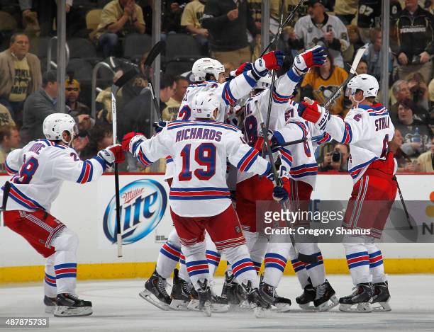 Derick Brassard of the New York Rangers is congratulated by teammates after his overtime goal against the Pittsburgh Penguins in Game One of the...