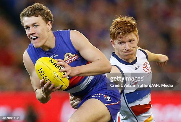 Jack Macrae of the Bulldogs is tackled by Kyle Cheney of the Crows during the 2015 AFL Second Elimination Final match between the Western Bulldogs...