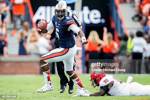 Quarterback Jeremy Johnson of the Auburn Tigers scrambles to avoid a tackle by defensive end Chris Landrum of the Jacksonville State Gamecocks on...