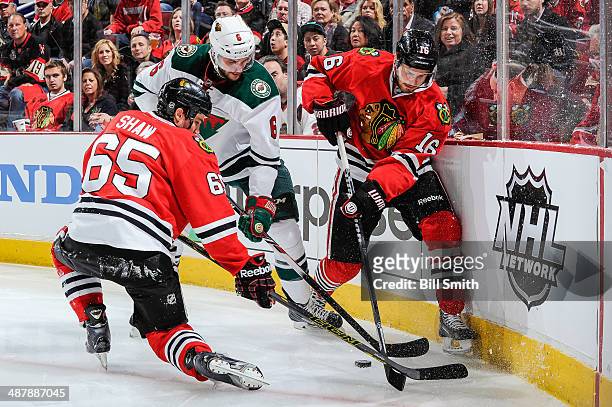 Andrew Shaw and Marcus Kruger of the Chicago Blackhawks battle for the puck against Marco Scandella of the Minnesota Wild in Game One of the Second...
