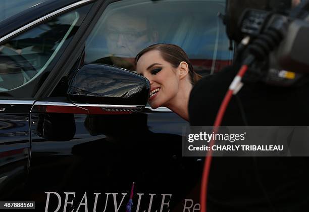 French actress Louise Bourgoin looks at herself in a rearview mirror as she arrives on the red carpet before the closing ceremony of the 41th...
