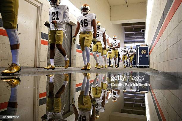 The Notre Dame Fighting Irish walk to the field for warmups before playing the Virginia Cavaliers at Scott Stadium on September 12, 2015 in...