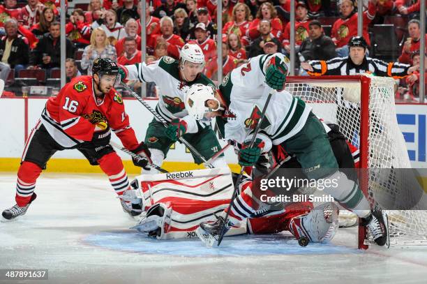 Jason Pominville and Mikael Granlund of the Minnesota Wild watch as goalie Corey Crawford of the Chicago Blackhawks attempts to stop the puck which...