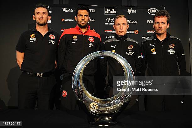Wanderes coach Tony Popovic and Nikolai Topor-Stanley of the Wanderers pose with the champions trophy with Matthew Smith of the Roar and Roar coach...