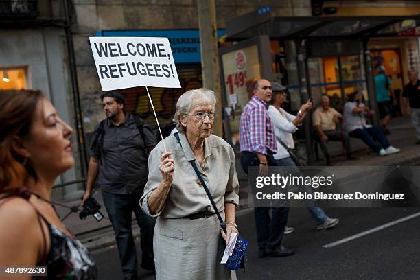 Woman holds a placard reading 'Welcome refugees!' as she takes part in a demonstration to show solidarity and support for refugees on September 12,...