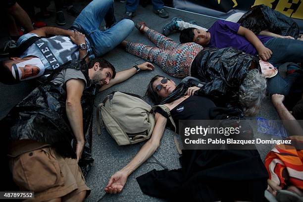 Protesters lay on the ground during a performance at the end of a demonstration to show solidarity and support for refugees on September 12, 2015 in...