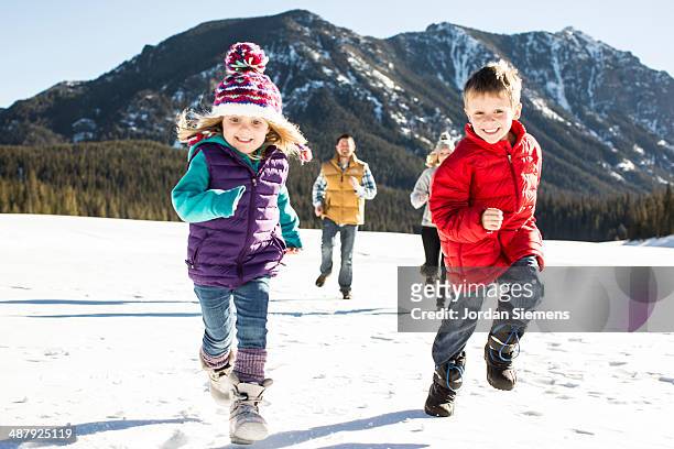 family running in the snow. - warme kleding stockfoto's en -beelden