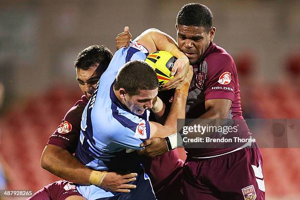 Adam Elliott of the NSW is tackled by is tackled by the QLD defence during the U20's State of Origin match between the New South Wales Blues and the...