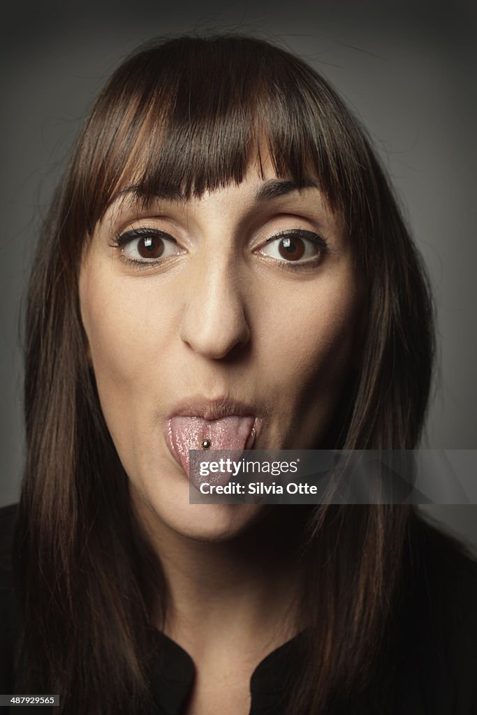 Portrait of woman with tongue piercing